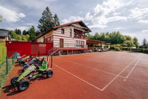 a house with a tennis court with a building at Penzion Rak Wellness in Černá v Pošumaví