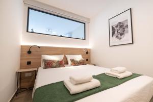 a bedroom with a large white bed with a window at GOZO DIVE Residence in Xlendi