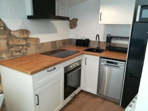 a kitchen with white cabinets and a black refrigerator at Mas Lloretó - El Rossinyol in Copóns