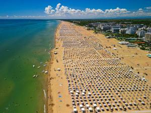 an aerial view of a beach with chairs and umbrellas at Hotel Europa in Bibione