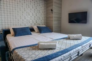 a bedroom with a large bed with blue pillows at Hotel Fiesa in Piran