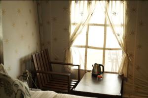 a bedroom with a table and a chair and a window at Tiger Resort Boho in Khilchipur