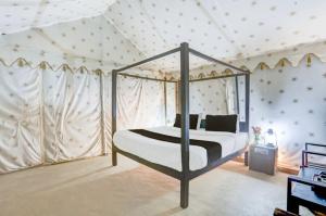 a bedroom with a canopy bed in a tent at Tiger Resort Boho in Khilchipur