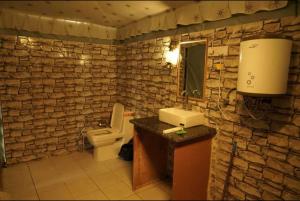 a stone bathroom with a toilet and a sink at Tiger Resort Boho in Khilchipur +40 photos