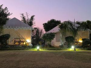 a couple of tents with lights in the yard at Tiger Resort Boho in Khilchipur