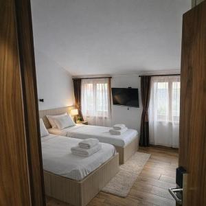 a bedroom with two beds and a tv on the wall at IMAGINATOR RESIDENCE-Pool is extra pay- Parking 2 free space in Novi Sad +38 photos