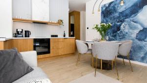 a living room with a table and chairs and a kitchen at Sol Marina 231 in Wiślinka
