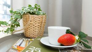 a cup and a strawberry on a table at Sol Marina 231 in Wiślinka