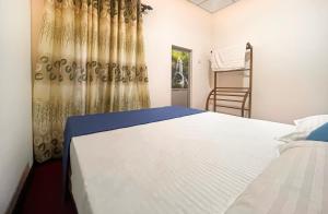 a bedroom with a white bed and a ladder at Dan Sewana in Nochchiyagama