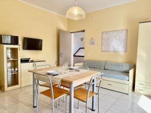 a dining room with a table and chairs and a couch at Bran & Denise Residence in Costermano