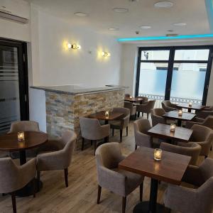 a restaurant with tables and chairs and a fireplace at IMAGINATOR RESIDENCE-Pool is extra pay- Parking 2 free space in Novi Sad