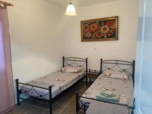two beds in a room with a picture on the wall at Mimi's House 2 in Véssa