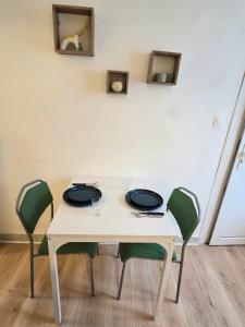 a white table with chairs and glasses on it at A l'orée de Croix - AbsoluteHome in Croix
