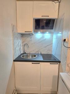 a small kitchen with a sink and a microwave at A l'orée de Croix - AbsoluteHome in Croix