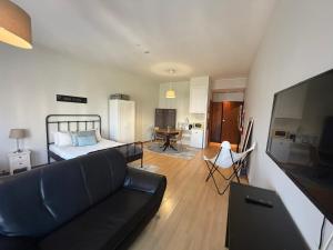 a living room with a black couch and a bed at Oporto Trindade Residence in Porto