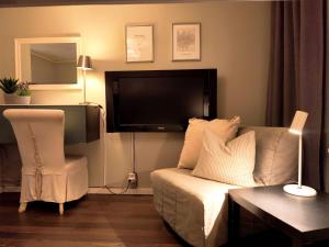 a living room with a couch and a flat screen tv at Hotell Trasten Tylösand in Tylösand