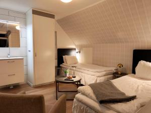a small room with two beds and a table at Hotell Trasten Tylösand in Tylösand