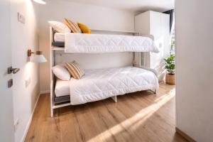 a room with two bunk beds and a couch at Bormio7 con parcheggio, pista ciclabile, vicino piste sci e terme in Valdisotto