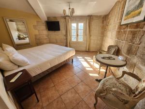 a bedroom with a bed and a table and chairs at Hôtel du Palais des Papes in Avignon