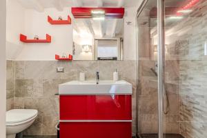 a bathroom with a red sink and a toilet at Charming Mezzanino in Siena +33 photos