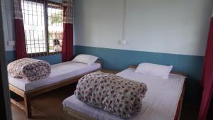 two twin beds in a room with two windows at Hotel mardi station and restaurent in Astam