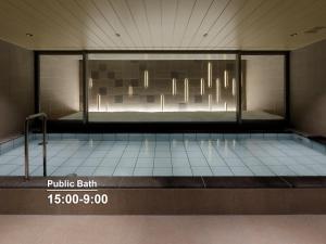 a room with a swimming pool with a glass wall at Mitsui Garden Hotel Sapporo in Sapporo