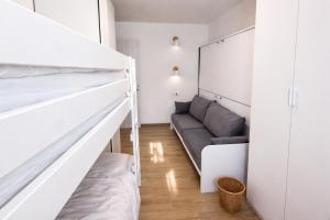 a bedroom with a bunk bed and a couch at Bormio7 con parcheggio, pista ciclabile, vicino piste sci e terme in Valdisotto +23 photos