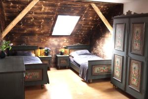 a attic bedroom with two beds and a window at Ferienhaus Ferienwohnung CasaBergZeit mit Königscard im Allgäu, Pfronten, Füssen in Pfronten