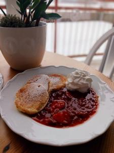 a plate of food with pancakes and jam and whipped cream at Penzion Rak Wellness in Černá v Pošumaví +109 photos