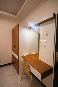 a room with a wooden table and a cabinet at erode kongu mess in Chennai