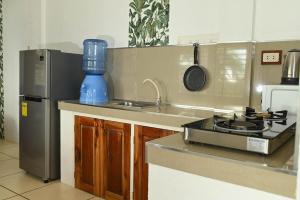a kitchen with a sink and a stove and a refrigerator at el balcon camiguin in Mambajao