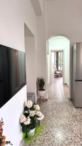 a living room with a tv and flowers on the wall at Πέτρινη φωλιά in Livadi