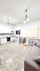 a living room with a couch and a kitchen at Πέτρινη φωλιά in Livadi