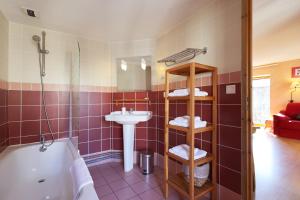 a bathroom with a sink and a toilet and a tub at Hôtel Picheyre in Formiguères