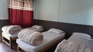 two beds with blankets on them in a room at Hotel mardi station and restaurent in Astam +15 photos