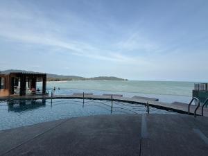 a swimming pool next to a body of water at Swiss Cozy Studio Kuantan City View Imperium Residence in Kuantan