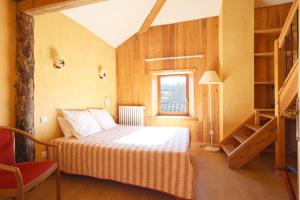 a bedroom with a bed and a window and a staircase at Hôtel Picheyre in Formiguères