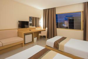 una camera d'albergo con un letto e una scrivania di Navarat Heritage Hotel a Kamphaeng Phet