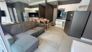 a living room with a couch and a kitchen at สุขุมวิท101 By KT in Amphoe Phra Khanong
