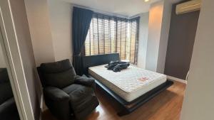 a bedroom with a bed and a chair and a window at สุขุมวิท101 By KT in Amphoe Phra Khanong +20 photos