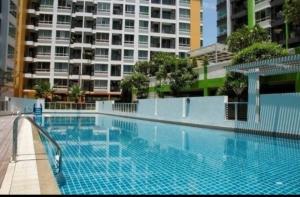 a large blue swimming pool with a large building at สุขุมวิท101 By KT in Amphoe Phra Khanong