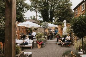 a group of people sitting in a patio with umbrellas at Tower Hotel in Lincoln
