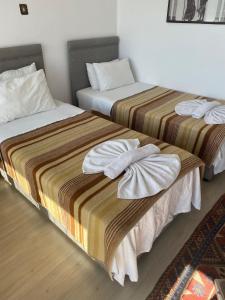two beds sitting next to each other in a room at Hotel Hisarlık in Halileli