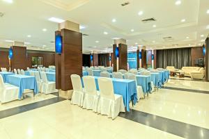 una sala banchetti con tavoli blu e sedie bianche di Navarat Heritage Hotel a Kamphaeng Phet Altre 65 foto