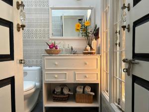 a bathroom with a sink and a toilet and a mirror at Crepe Ginger Home Stays in Hariharpur