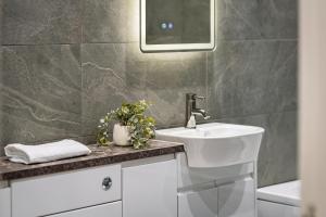 a bathroom with a sink and a mirror at The Gleneagles Hideaway - Luxury 3 Bed With Complimentary Access to Onsite Leisure Facilities in Gleneagles Station +29 photos