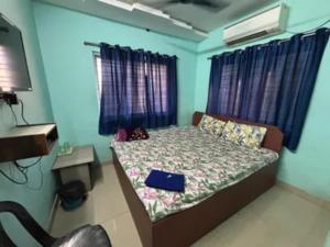 a bedroom with a bed with blue walls at Via Ashiyana Inn in Kolkata