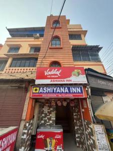 a building with a sign in front of a store at Via Ashiyana Inn in Kolkata