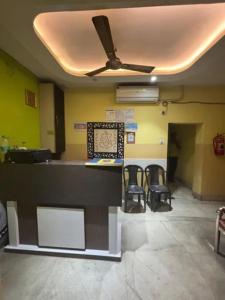 a room with a counter with chairs and a ceiling at Via Ashiyana Inn in Kolkata