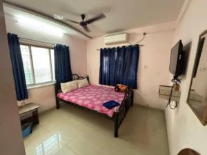 a small bedroom with a bed and a tv at Via Ashiyana Inn in Kolkata +18 photos